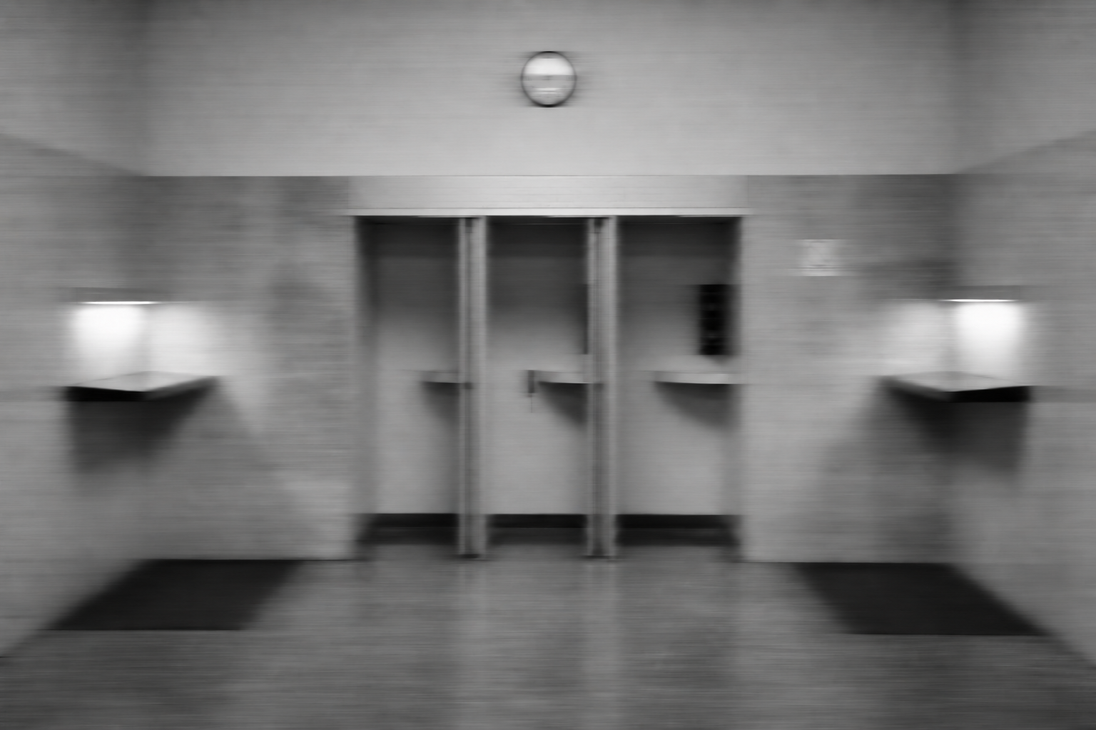 A motion-blurred black-and-white telephone lobby